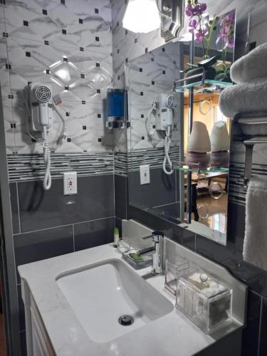 a bathroom with a sink and a mirror at Towers by the Beach in Ocho Rios