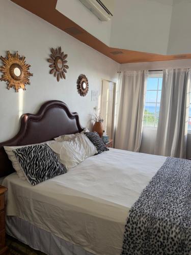 a bedroom with a bed and two mirrors on the wall at One more night in Ocho Rios