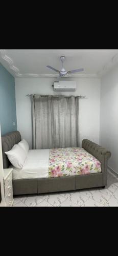 a bedroom with a bed with a floral bedspread at Brufut Residencies Apartment 5 in Brufut