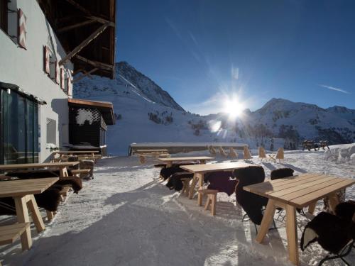 a group of wooden picnic tables in the snow at Hotel Jagdschloss Resort in Kühtai