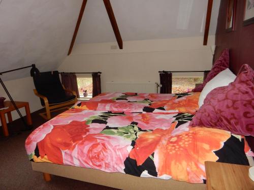 a bedroom with a bed with a colorful comforter at Bed & Breakfast Onder Dak in Scharmer