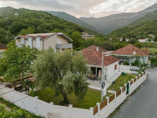 a house with a white fence next to a river at House Olive Tree in Bijela