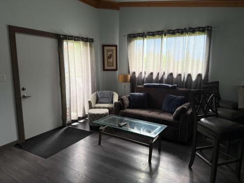 a living room with a couch and chairs and a table at Pine Marten Wilderness Cabin - Hot Tub & Mountain Views in Golden