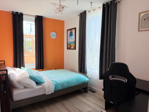 a bedroom with orange walls and a bed and a window at Manoir Chris in Saint-Augustin-de-Desmaures