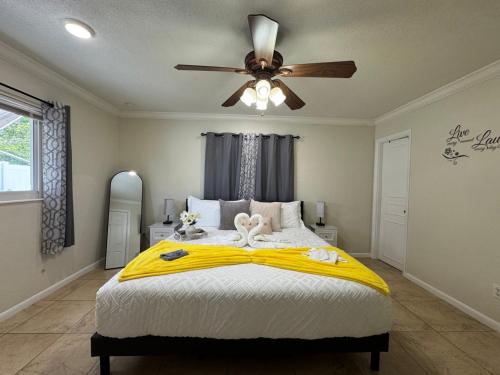 a bedroom with a bed with a ceiling fan at Sunshine Nest in Lehigh Acres