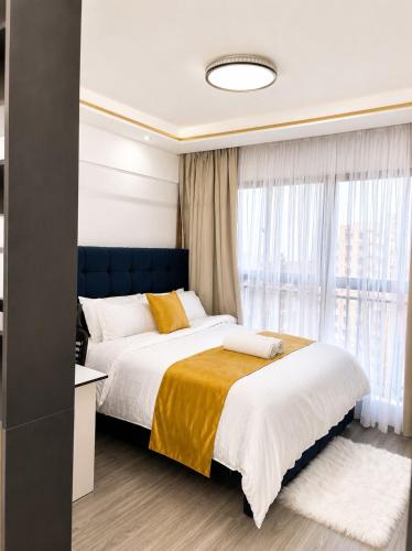 a bedroom with a large bed and a window at Alina Ridge in Nairobi