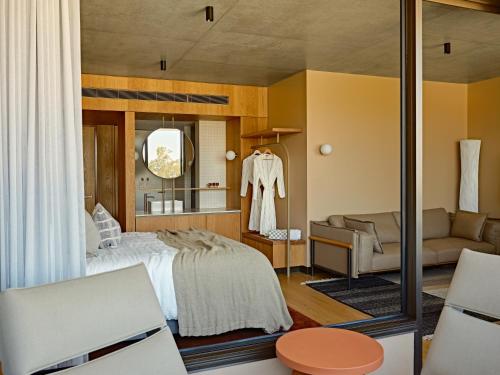 a bedroom with a bed and a couch at Hotel Marvell Byron Bay in Byron Bay