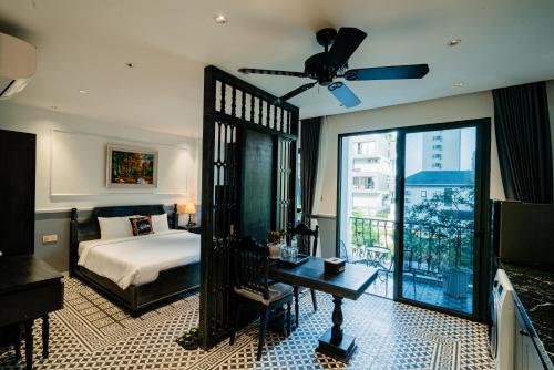 a bedroom with a bed and a ceiling fan at Dérive Boutique Villa & Apartment Da Nang in Danang