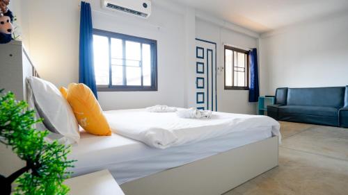 a bedroom with a white bed and a blue couch at Three Monkeys Mae Nam beach in Mae Nam