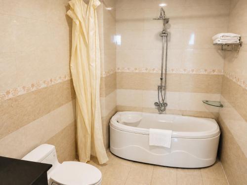 a bathroom with a toilet and a tub at Tây Nam 2 Hotel in Can Tho