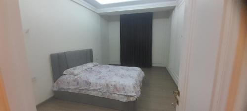 a bedroom with a bed in a room with a window at Hakim Karim Apartments in Khujand