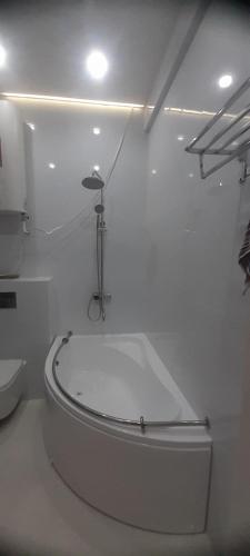 a white bathroom with a bath tub in a room at Hakim Karim Apartments in Khujand