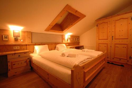 ein Schlafzimmer mit einem großen Holzbett mit weißer Bettwäsche in der Unterkunft Almliesl ZELL-411 in Zell am See