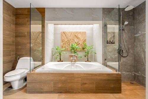 a bathroom with a tub and a toilet and a sink at Fair House Villas & Spa, Koh Samui in Mae Nam