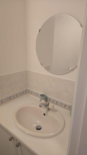 a white sink in a bathroom with a mirror at Hilcot House in Kirby Muxloe