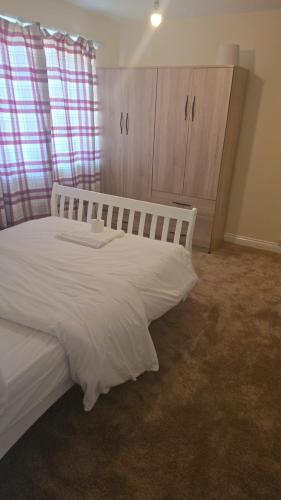 a bedroom with a large white bed in a room at Hilcot House in Kirby Muxloe