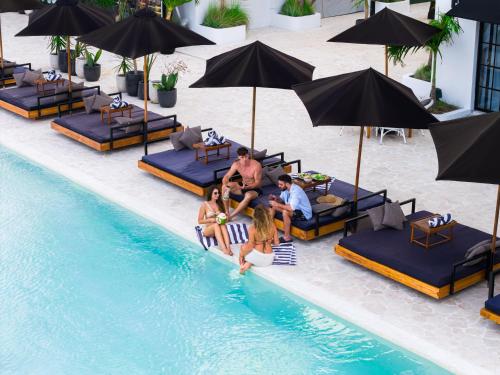 a group of people sitting in the pool at a resort at Kiara Beachtown Nusa Dua in Nusa Dua