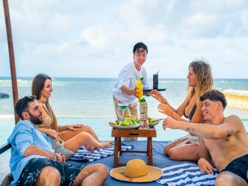 a group of people sitting on the beach at Kiara Beachtown Nusa Dua in Nusa Dua