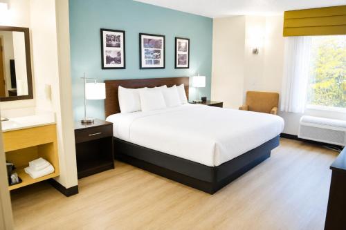 a bedroom with a large bed and a bathroom at Sleep Inn Staunton in Staunton