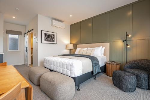 a bedroom with a large bed and two chairs at The Stables Motel in Bulls