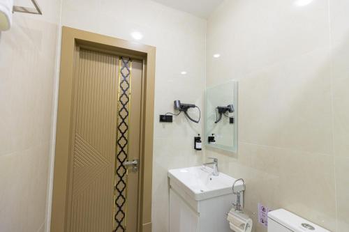 a bathroom with a toilet and a sink and a mirror at Boutique Hotel IMONA in Samarkand