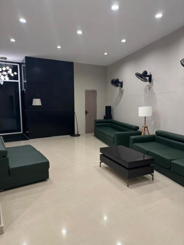 a large living room with green couches and a table at King Residency in Chennai