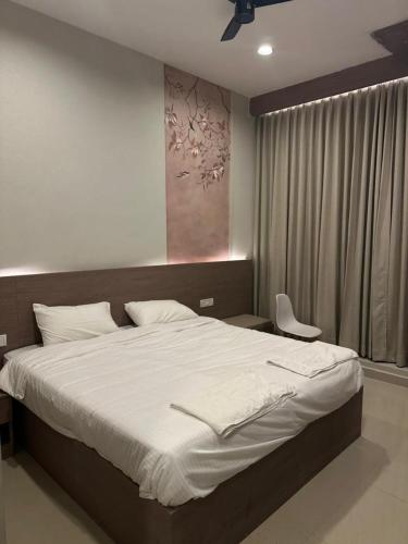 a bedroom with a large bed and a chair at King Residency in Chennai