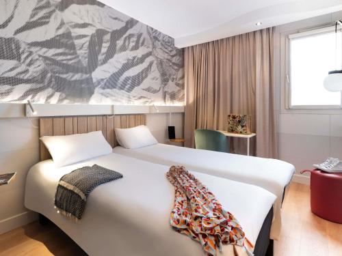 a bedroom with a large white bed in a room at ibis Macon Sud Crêches in Crêches-sur-Saône