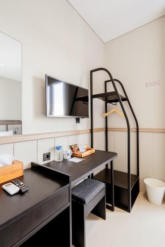 a room with a desk and a mirror at Rucio Kostel Semarang in Jatingaleh