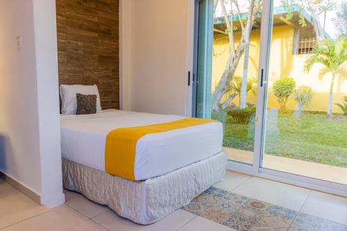 a bedroom with a bed and a large window at Hotel Scarlette in Tulum