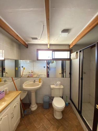 a bathroom with a toilet and a sink at Spacious Beach House with Pool for Relaxing in El Quisco