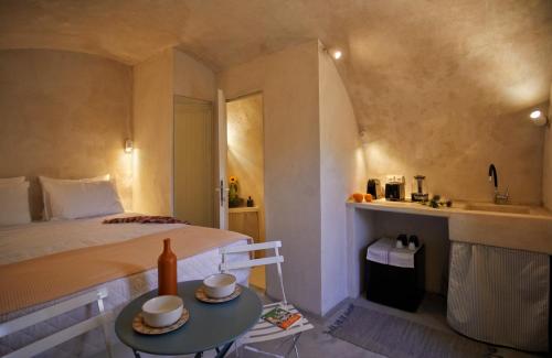a bedroom with a bed and a table with two cups on it at 318 Oia Villa in Oia