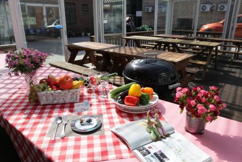a picnic table with fruits and vegetables and a grill at Daecheon jeulgeoun pension in Boryeong