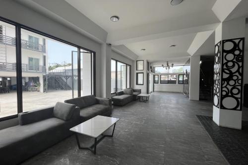 a living room with couches and a table and windows at VS Beach Front in Jomtien Beach