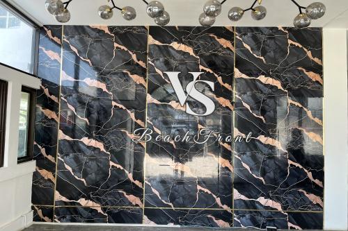 a large marble wall in a lobby with a barrett firm sign at VS Beach Front in Jomtien Beach