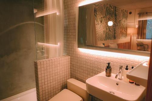 a bathroom with a sink and a toilet and a mirror at 那須パラダイスヴィレッジ Hotel PARADISO in Nasushiobara
