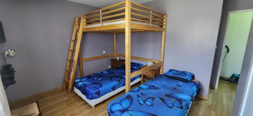 two bunk beds in a room with blue sheets at La Résidence de Lorelei in Cierp