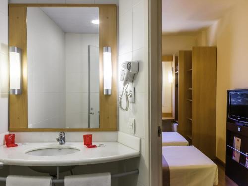 a bathroom with a sink and a mirror at ibis Toulouse Aeroport in Blagnac