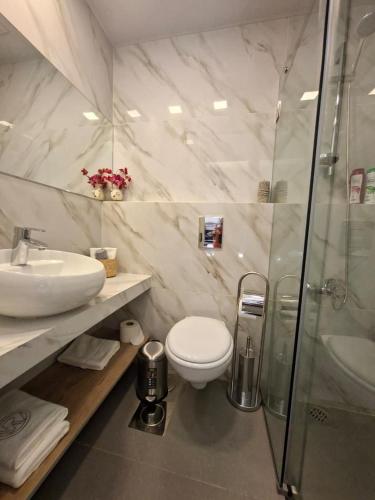 a bathroom with a sink and a toilet and a shower at Railway Studio 2 - Modern Studio in Byblos - Easy city Access in Jbeil