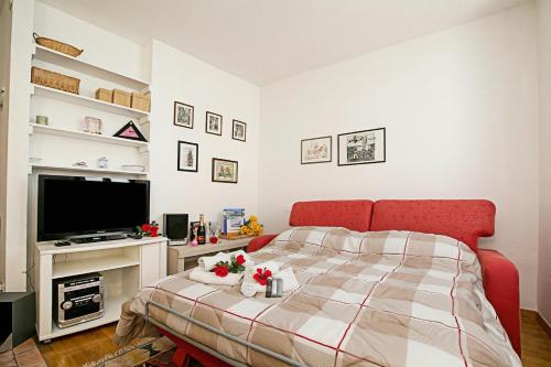 a bedroom with a bed and a flat screen tv at Appartamento Centro Storico Riva 2 - Happy Rentals in Riva del Garda