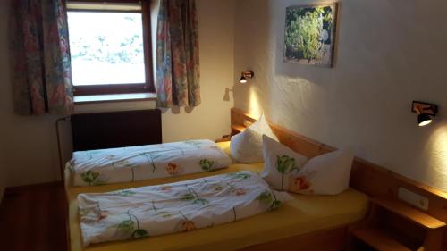 a bedroom with two beds and a window at Ferienwohnungen Wolf in Holzgau