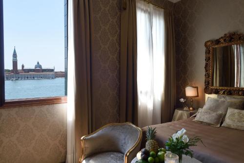 a bedroom with a bed with a window and a chair at Hotel Metropole Venezia in Venice
