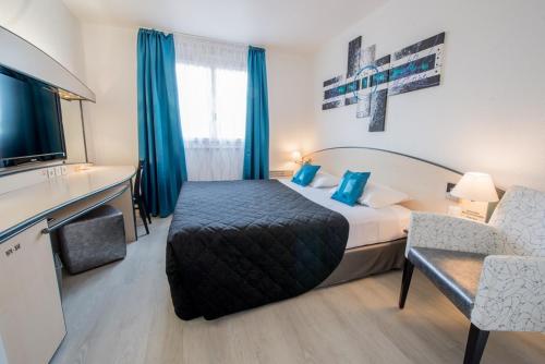 um quarto de hotel com uma cama e uma cadeira em Citotel Hôtel Le Capricorne em Marmande
