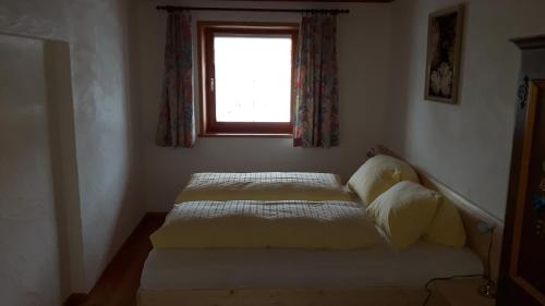a bed in a bedroom with a window at Ferienwohnungen Wolf in Holzgau