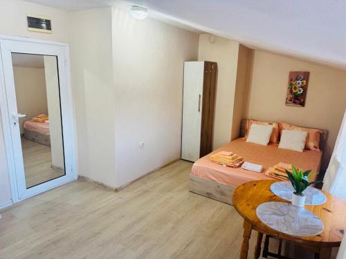 a bedroom with a bed and a table and a mirror at Room Nencheva in Sandanski
