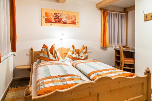a bedroom with a wooden bed with pillows on it at Biobauernhof Kleinummerstall in Mittersill