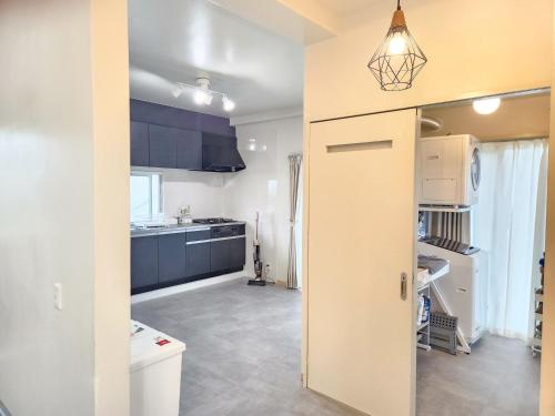 an open door to a kitchen with blue cabinets at seragaki blue twins 201 in Onna
