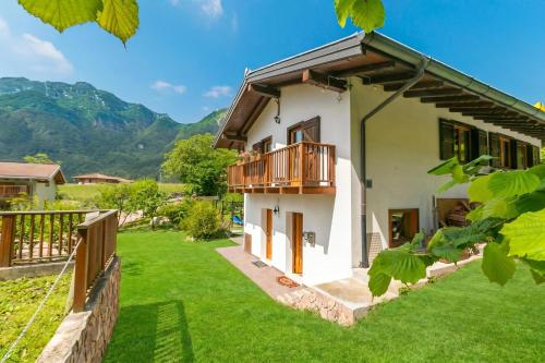 a house with a balcony and a yard at Casa Tra Borgo e Lago in Lake Tenno - Happy Rentals in Tenno