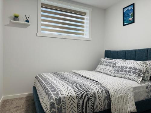 a bedroom with a bed and a window with a blanket at Chic City Escape- come experience tranquility! in Calgary