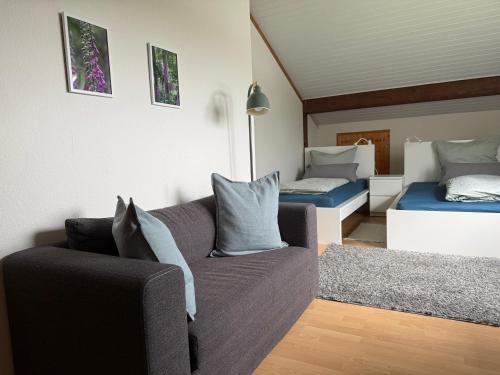a living room with a couch and two beds at Haus Eifeldolomiten - Ankommen und Wohlfühlen in Gerolstein